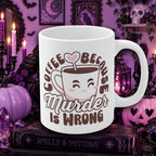 A white ceramic coffee mug with a cute cartoon cup graphic and the text 'COFFEE BECAUSE Murder IS WRONG' in brown, styled on a book surrounded by Halloween decorations like purple pumpkins, candles, and a skull in a purple gothic room.