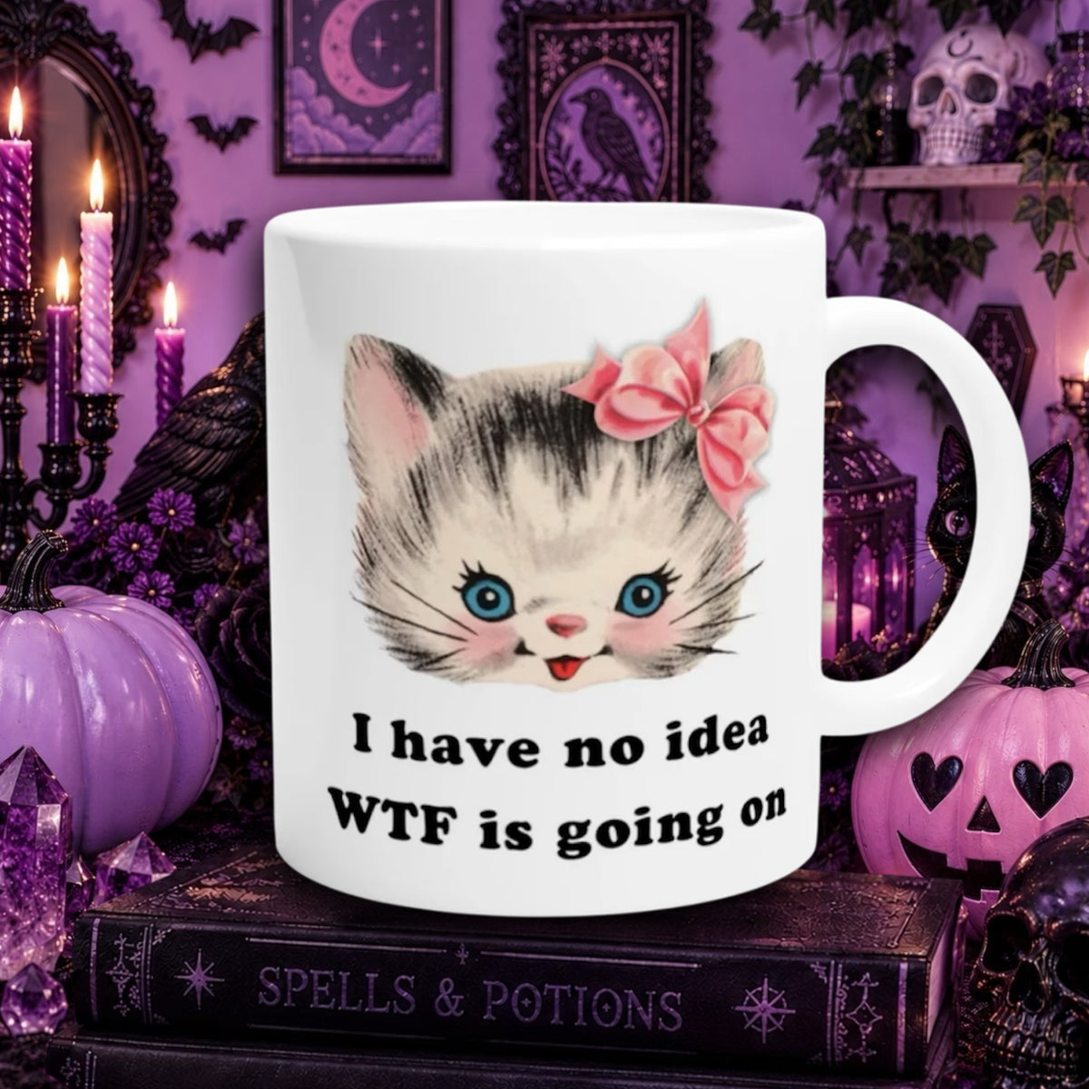 A white ceramic mug with a cute cartoon kitten face, with the text 'I have no idea WTF is going on' printed below. The mug is set against a spooky Halloween-themed background with purple pumpkins, candles, and a book labeled 'SPELLS & POTIONS'.