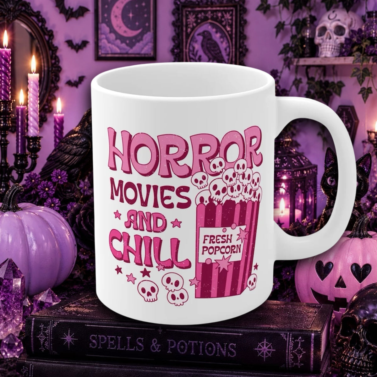 A white ceramic mug with a pink and red graphic that reads 'HORROR MOVIES AND CHILL' alongside a popcorn bucket illustration, set against a Halloween-themed purple background with pumpkins, candles, and books.