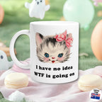 Retro Kitsch Mug with a cat illustration and funny text 'I have no idea WTF is going on' on a soft pink surface with macarons.