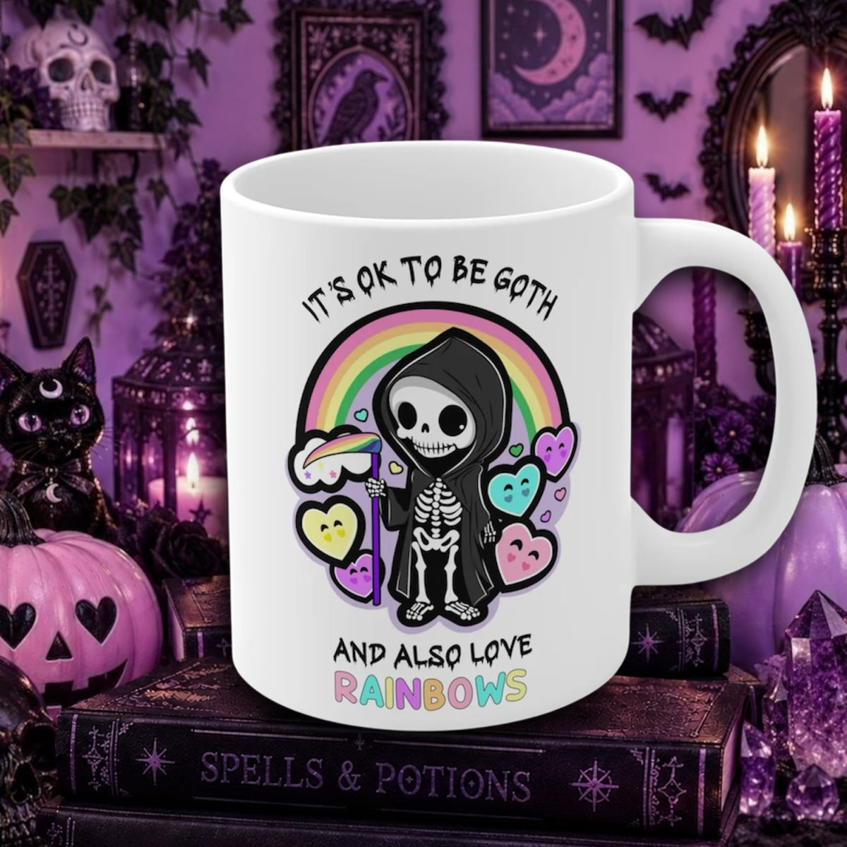 A white ceramic mug with a gothic skeleton and rainbow graphic, displayed on a stack of books in a purple Halloween-themed setting.