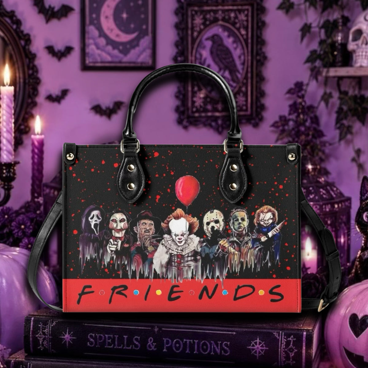 A black tote bag with a horror-themed Friends graphic featuring Pennywise, Sally, Michael, and other characters under a red balloon, with the word 'FRIENDS' in orange and blue on a red band. The bag is displayed on a purple Halloween-themed background with candles, framed artwork, and pumpkins.