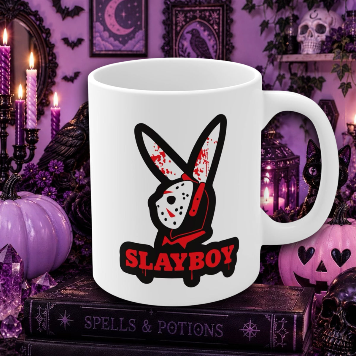 A white ceramic mug featuring a horror-themed graphic of a bunny wearing a hockey mask with blood splatters and the text 'SLAYBOY' in red and black. The mug is displayed in a spooky, purple-lit Halloween-themed room with candles, pumpkins, and books.