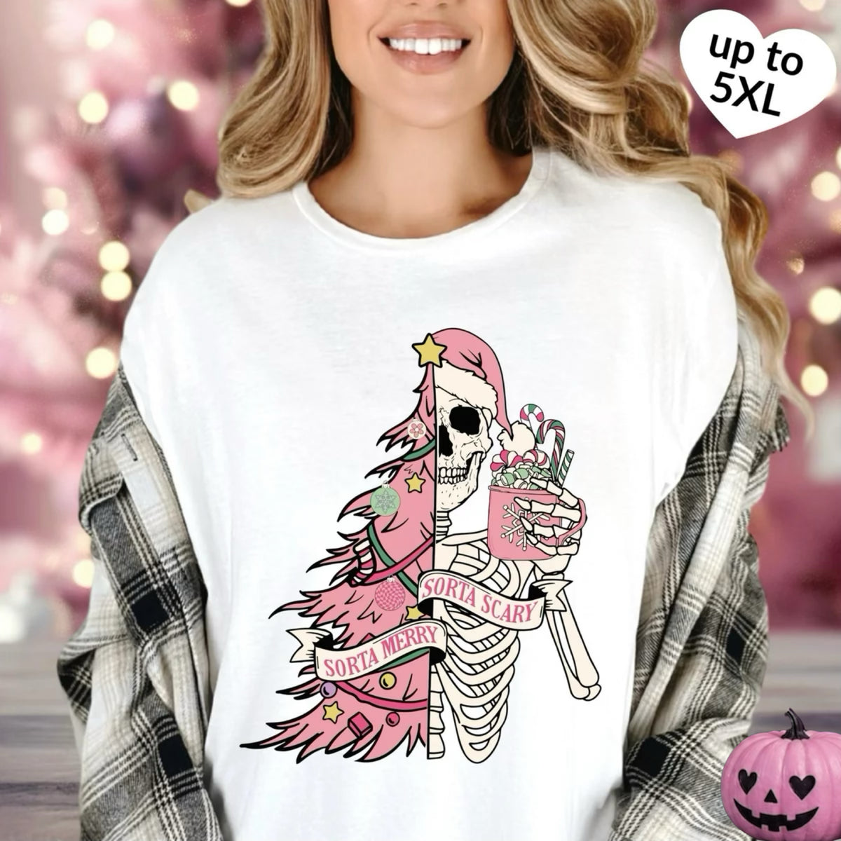 A woman wearing a white oversized graphic T-shirt with a pink and black Santa skeleton design, layered with a gray plaid flannel shirt. The background is a soft pink bokeh with holiday lights, and a heart-shaped badge in the top right reads 'up to 5XL'.