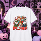 A white short-sleeve t-shirt hanging on a black hanger, featuring a colorful graphic of cute Labubu characters in Halloween costumes above the word 'HALLOWEEN' in red dripping letters. The shirt is displayed against a spooky purple Halloween-themed background with pumpkins, candles, and a black cat.