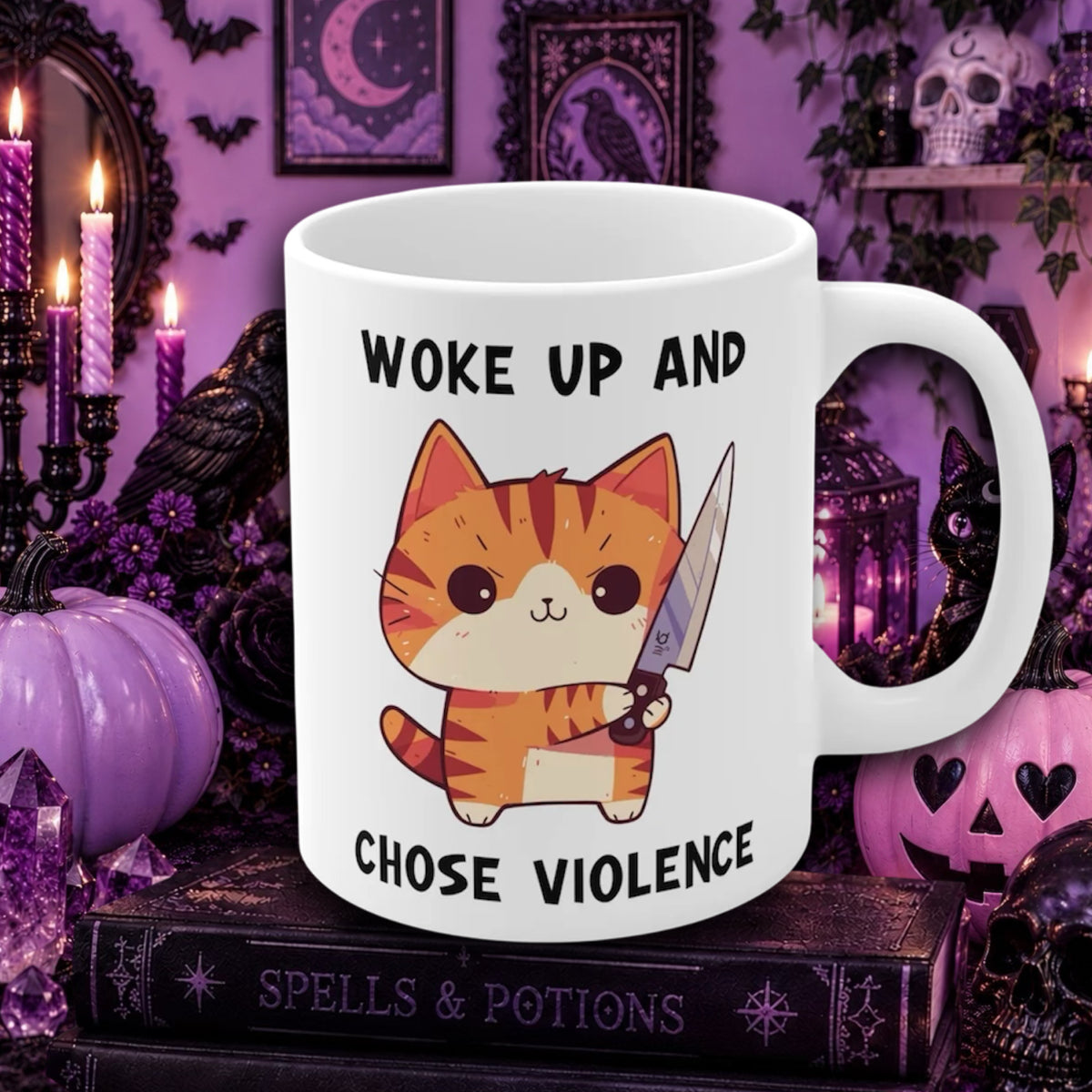A white ceramic mug with a cartoon orange tabby cat holding a knife, surrounded by the text 'WOKE UP AND CHOSE VIOLENCE'. The mug is set on a book labeled 'SPELLS & POTIONS' against a spooky purple Halloween background with pumpkins, candles, and black cats.